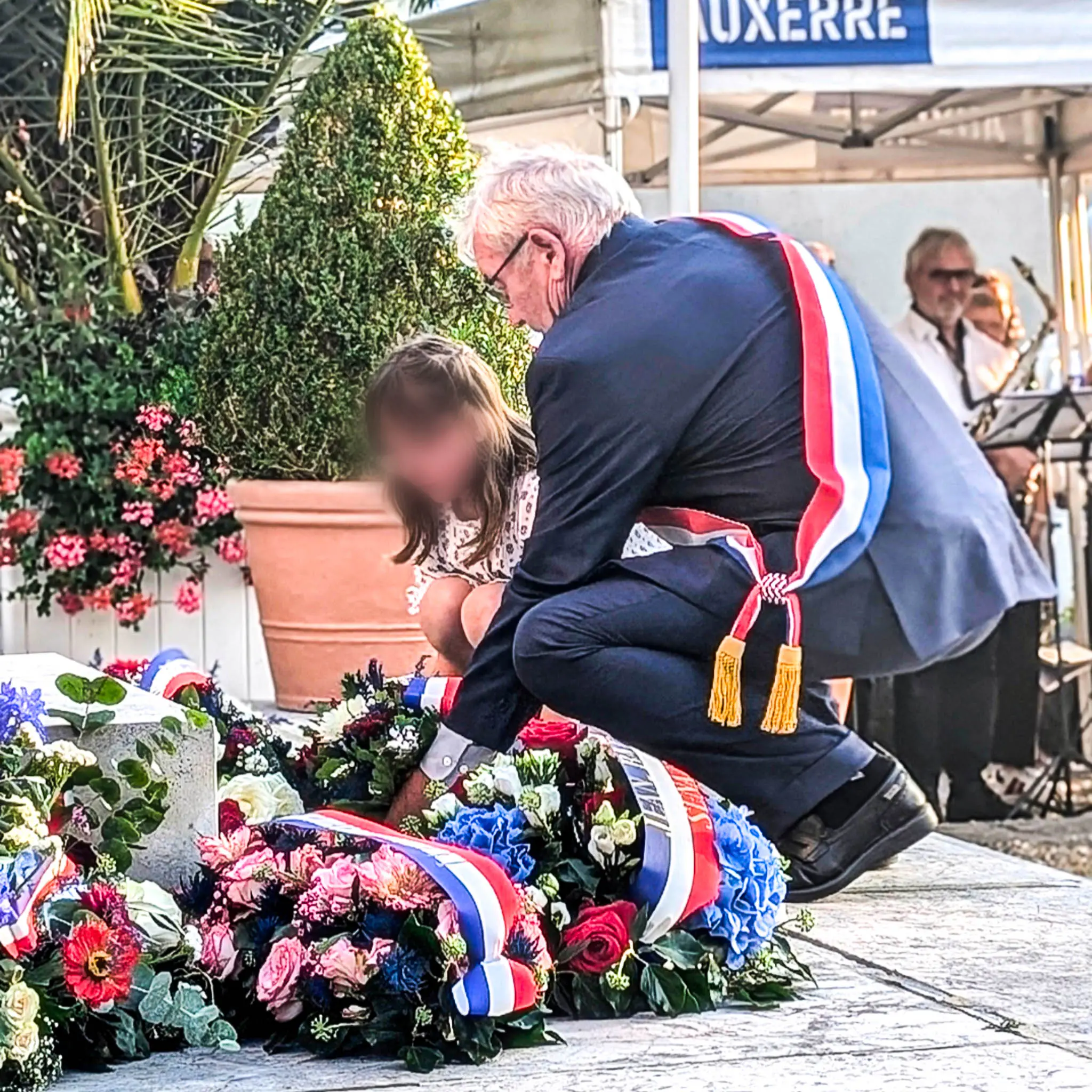 Daniel Grenon, député de l’Yonne, dépose une gerbe aux côtés d’une enfant lors d’une cérémonie du souvenir