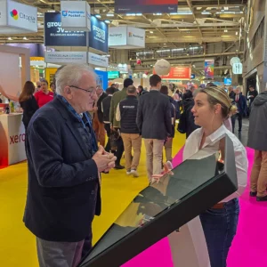 Daniel Grenon, député de l’Yonne, échange avec une exposante lors d’un salon dédié aux maires